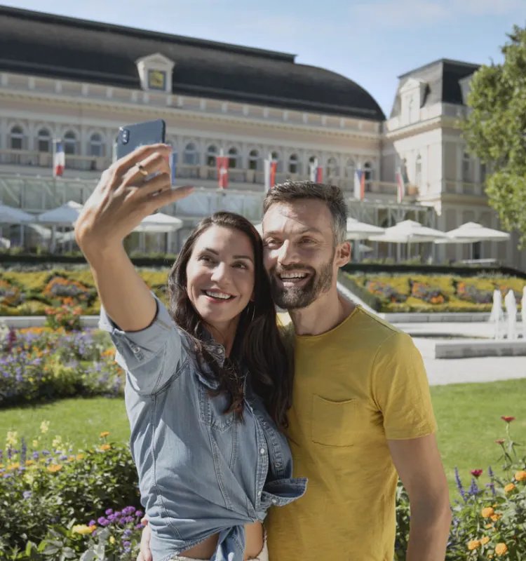 Ein Paar posiert für ein Selfie vor den historischen Sehenswürdigkeiten Bad Ischls