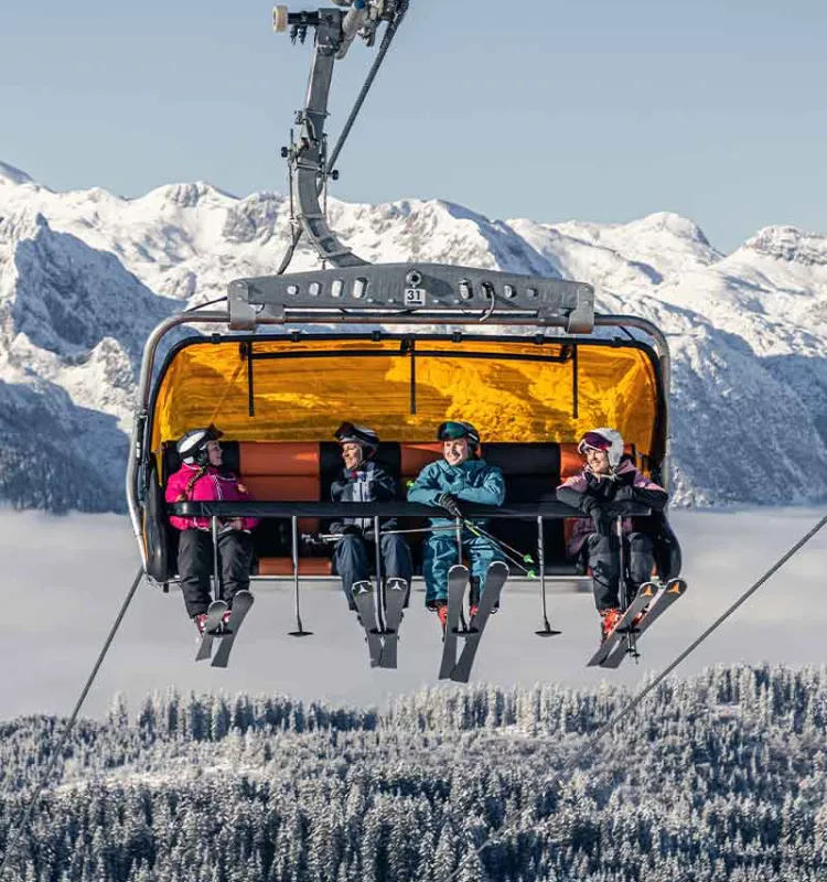 Skifahrer im Sessellift Dachstein West beim Snow Adventure Skiurlaub des Grand Elisabeth Hotels im Salzkammergut Österreich