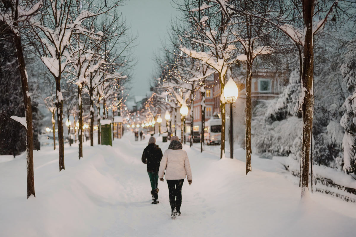 Verschneiter Weg mit Lichtern in Bad Ischl nahe dem Hotel Grand Elisabeth am Abend